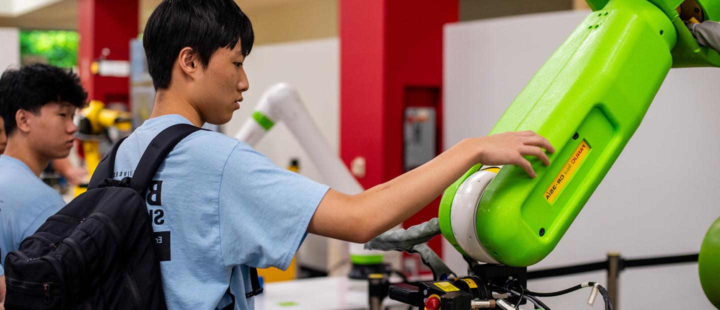 Students working with robotic machines in a lab.