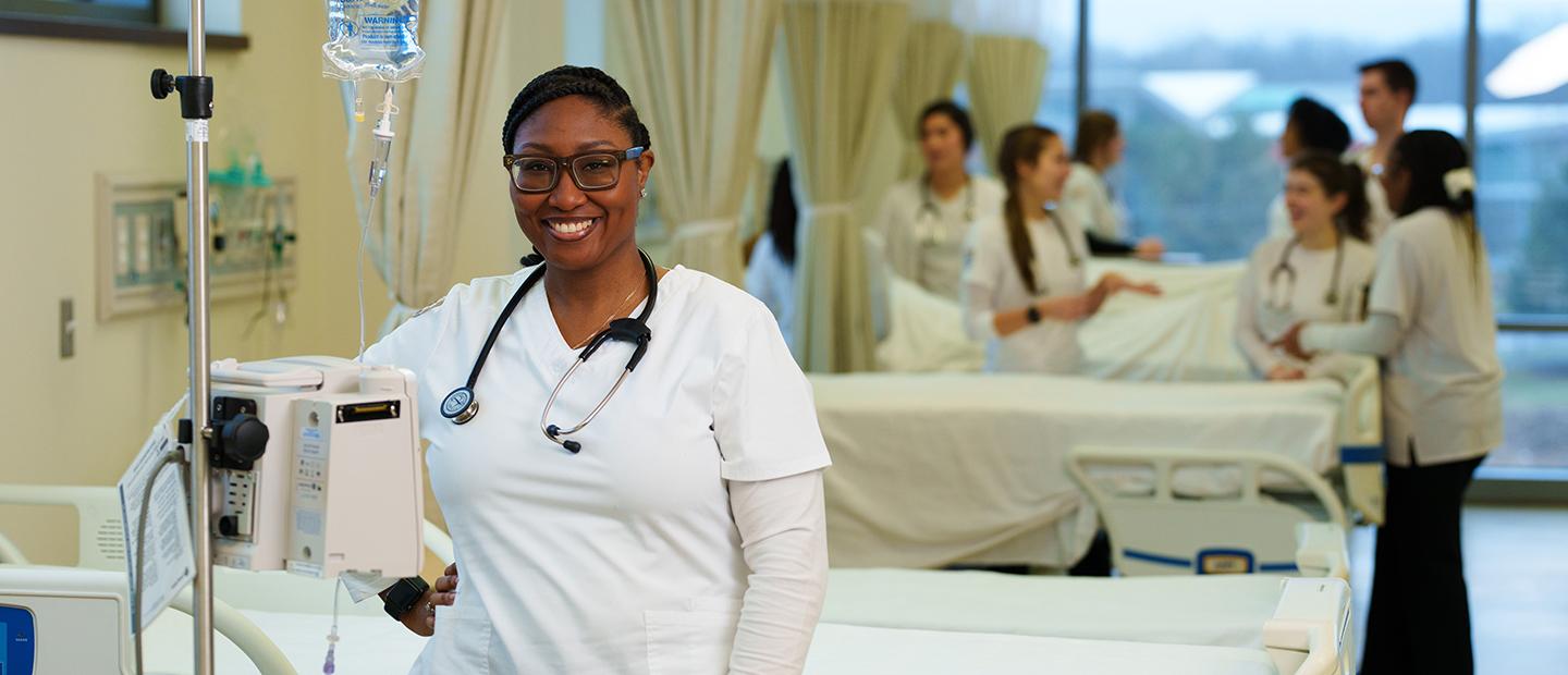 woman stadning in front of hospital bed smiling at camera